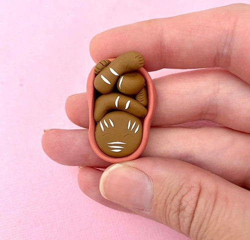 Indigenous baby in womb with body paint brooch