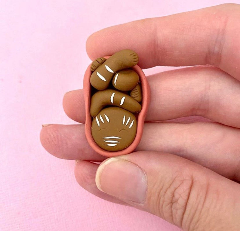 Indigenous baby in womb with body paint brooch